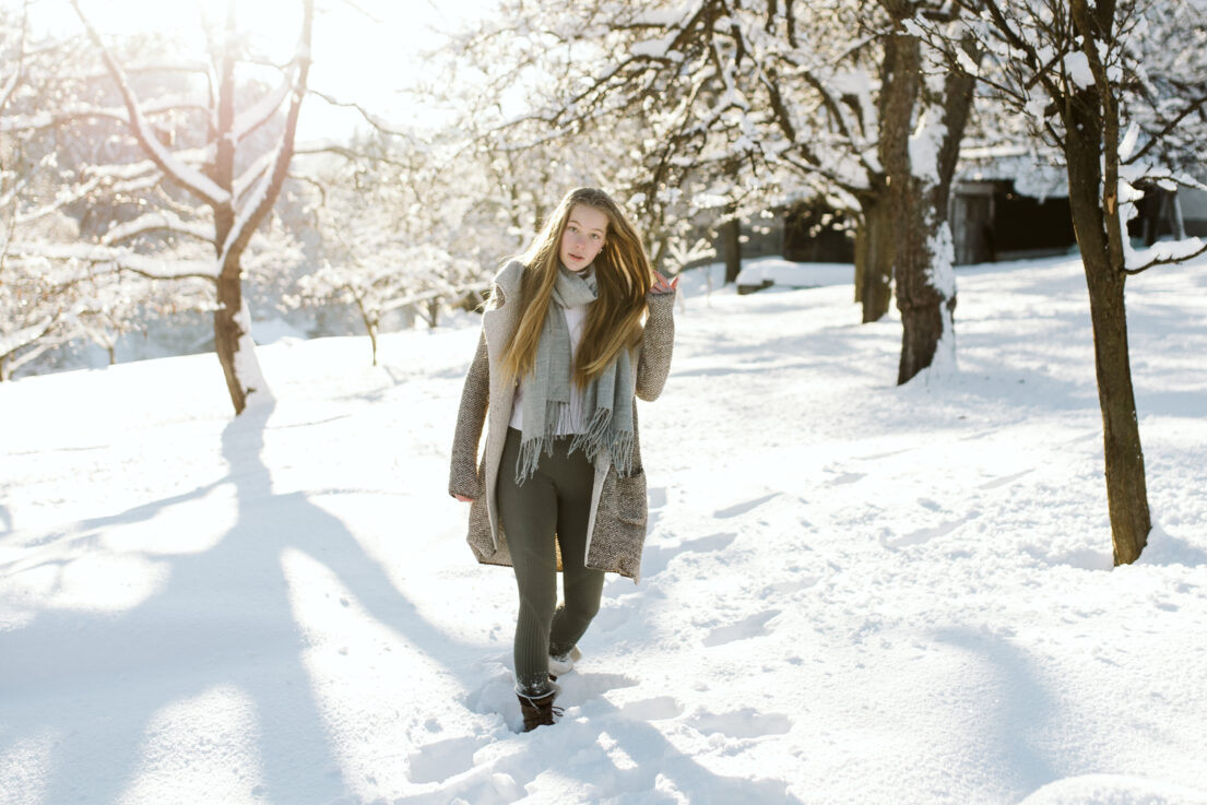 Modelka v zasněžené krajině při zimním portrétním focení