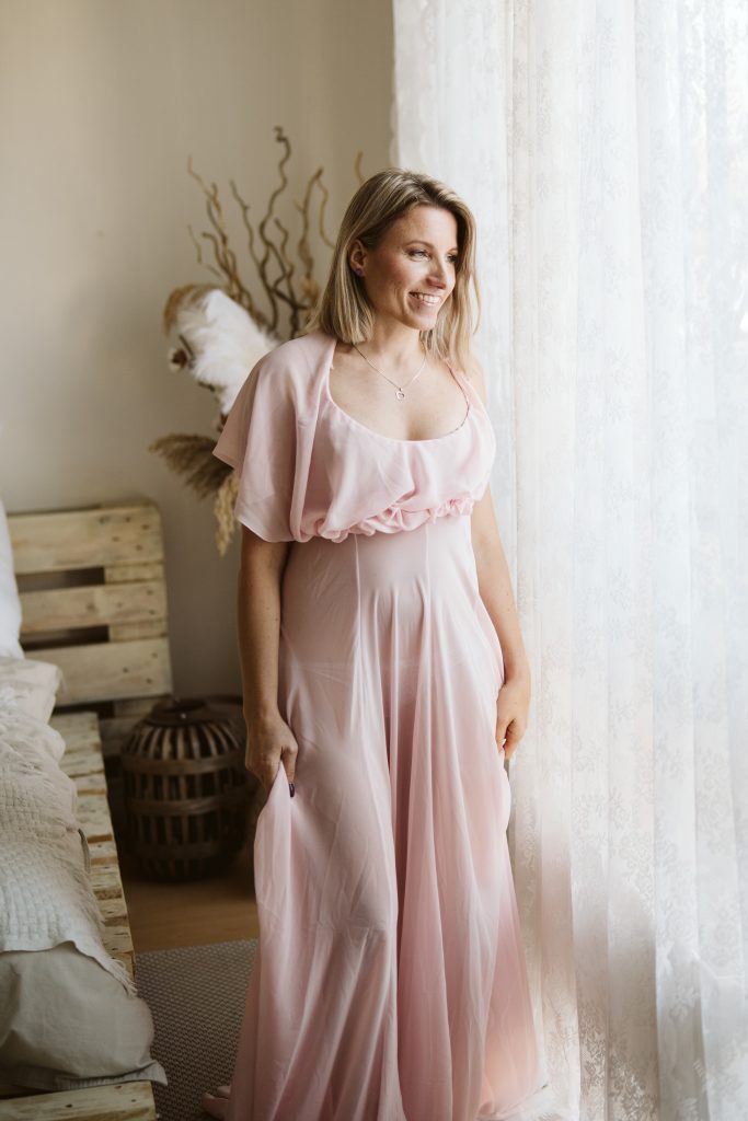 Žena ve světle růžových šatech na focení v ateliéru