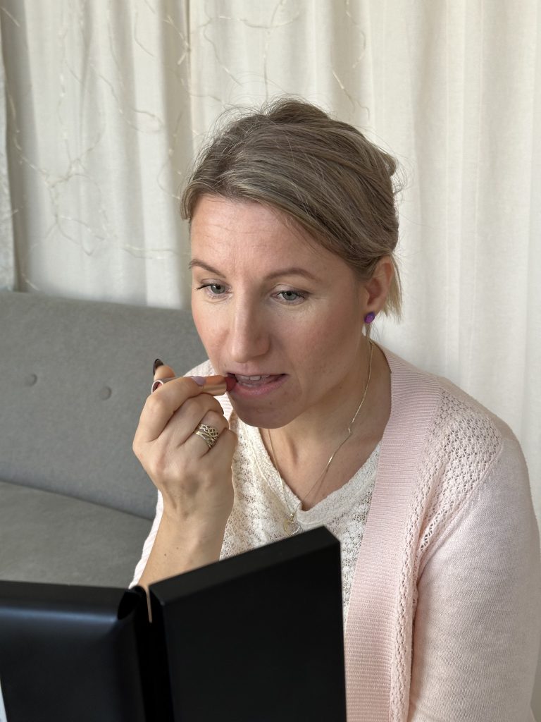 Žena si nanáší rtěnku