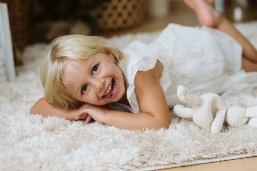 Holčička v bílých šatech ve fotoateliéru