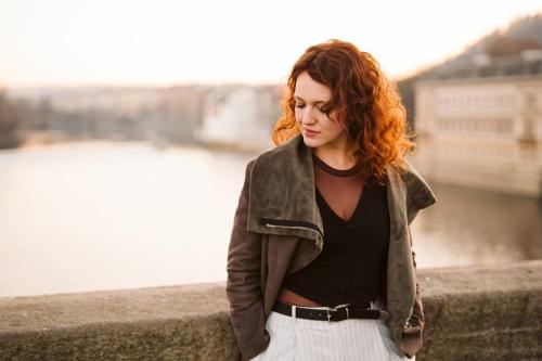 Portrét dívky s rezavými vlasy na Karlově mostě v Praze