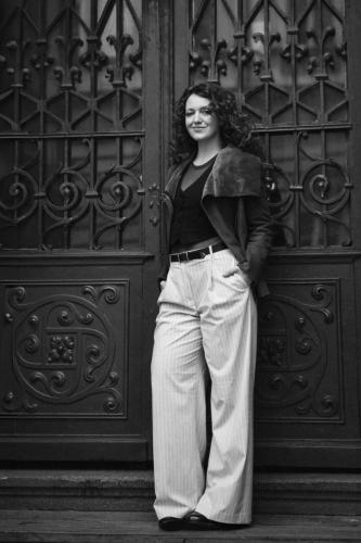 Portrét slečny na černobílé fotografii u kovových dveří