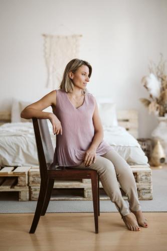 Žena s blond vlasy na hnědé židli při portrétním focení.