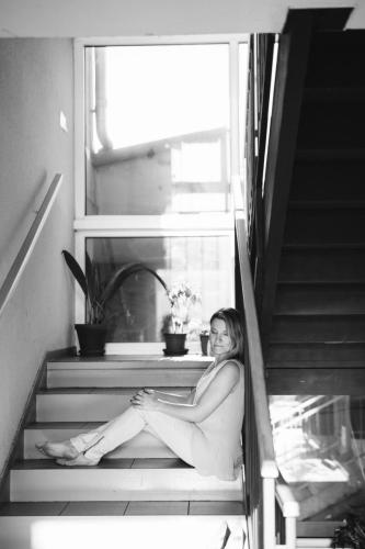 Černobílé foto ženy sedící na schodech na chodbě domu